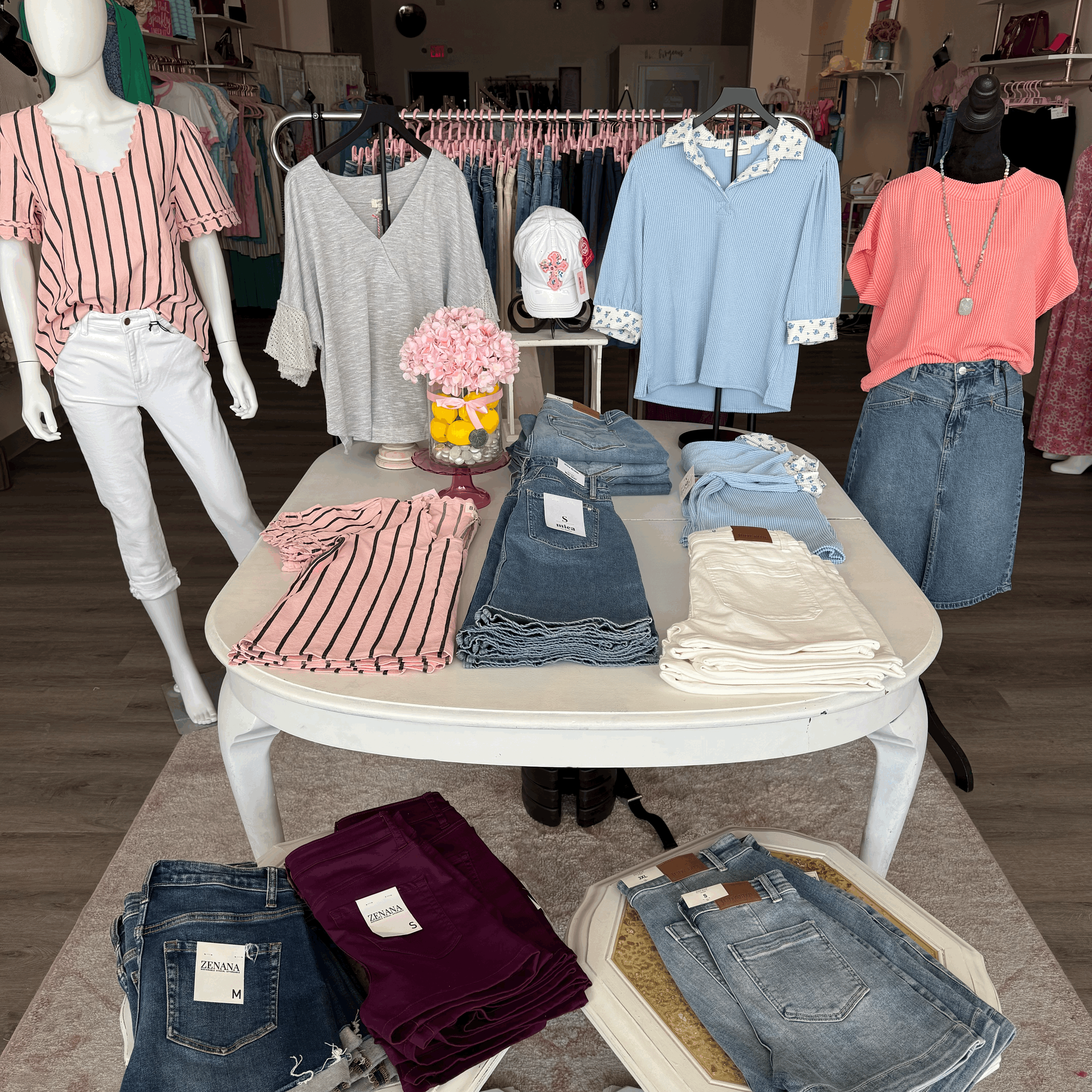 picture of white table with different colored tops and shorts folded on display.