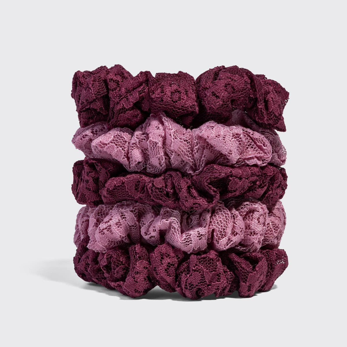 Stack of five KITSCH lace scrunchies alternating burgundy and dusty pink