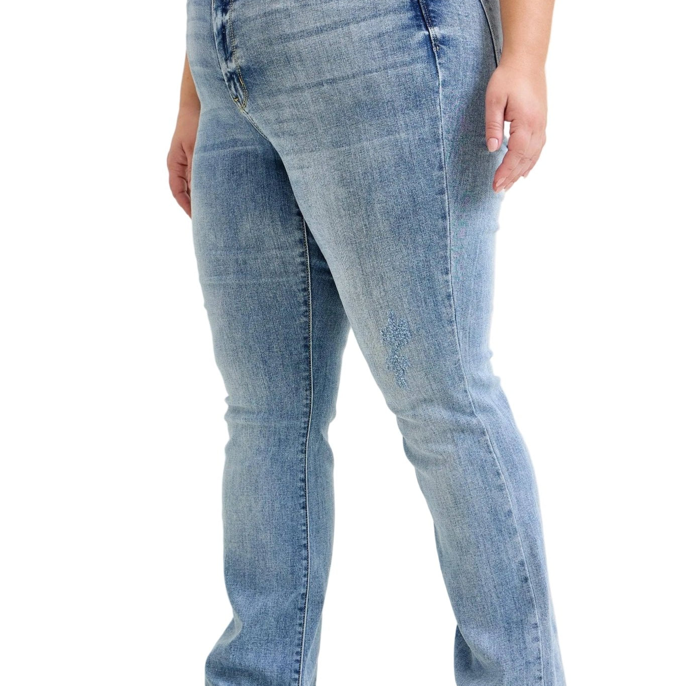 Person wearing light blue jeans on a plain background