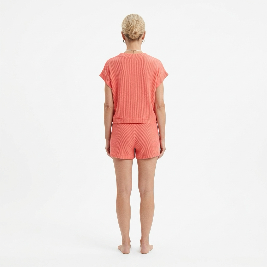 Person wearing a coral-colored outfit on a white background
