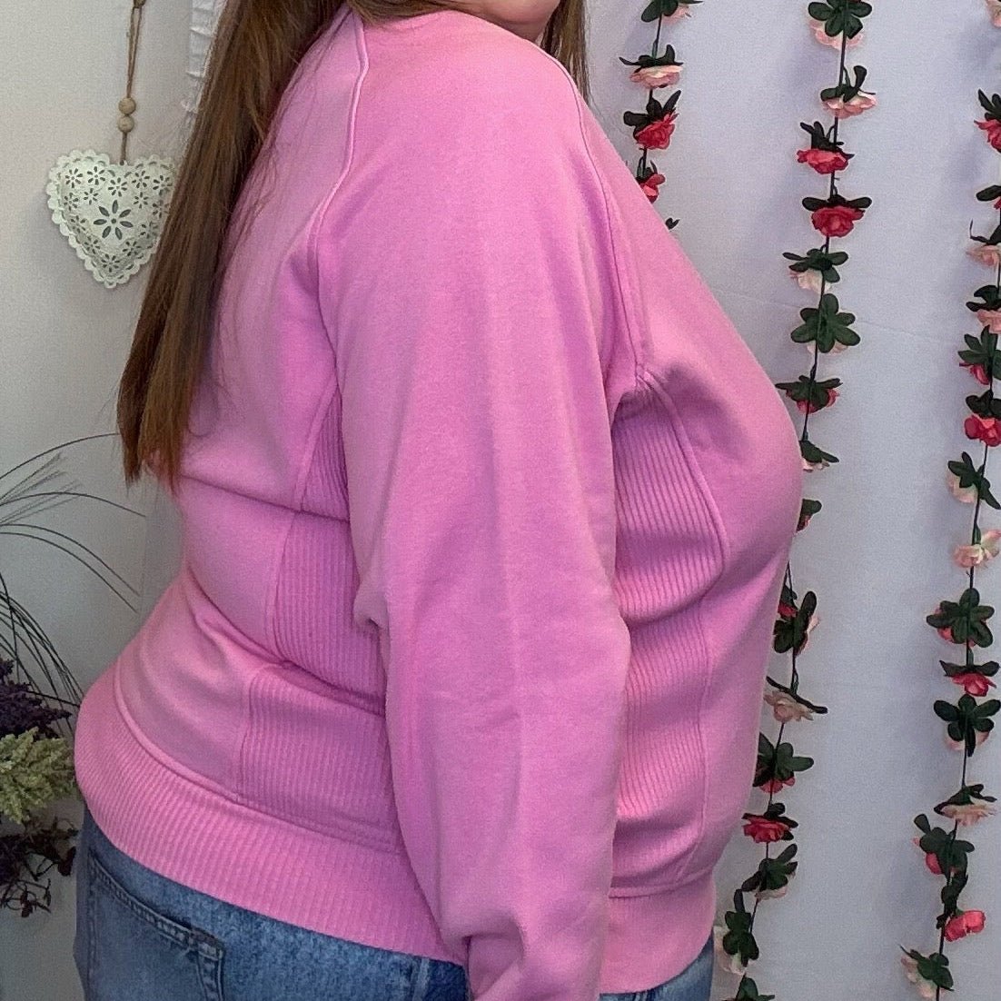 Side view of the plus size pink crewneck sweatshirt showing the relaxed fit and long sleeves