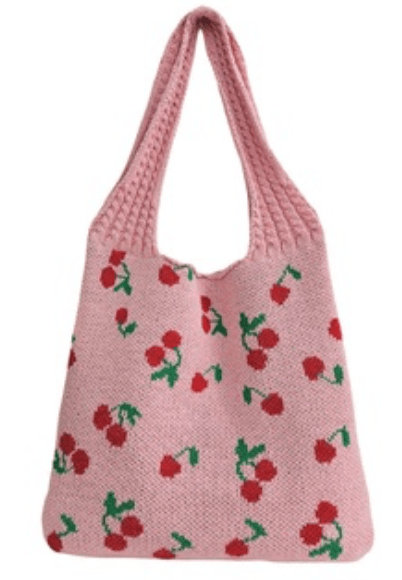 Pink knitted bag with cherry pattern on a white background