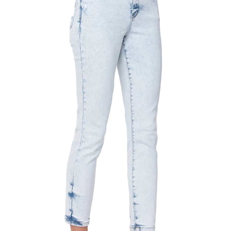 A person wearing light-wash blue cropped skinny jeans with faded detailing and brown strappy sandals, shown from the waist down against a plain light background.