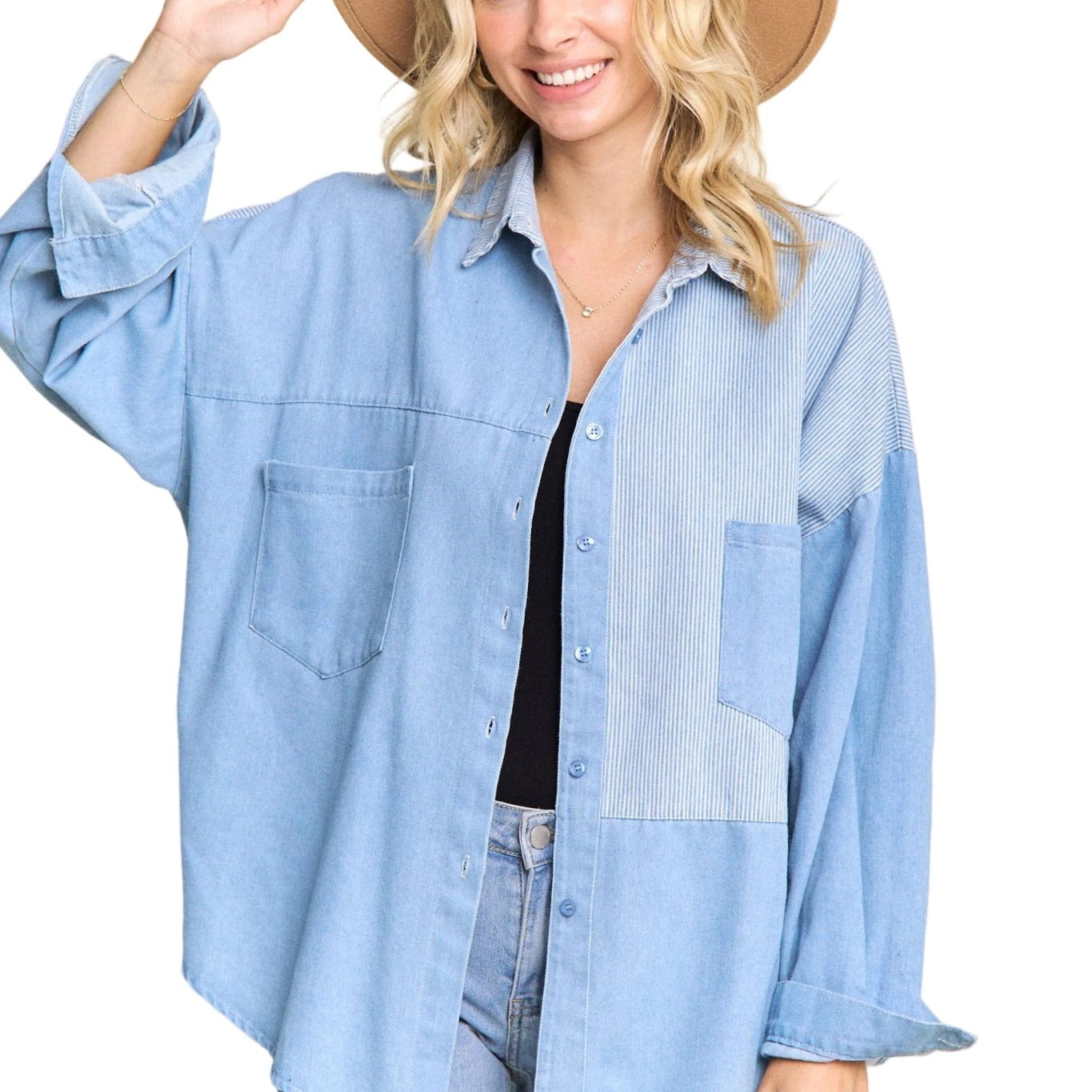 Woman wearing a light blue denim shirt and beige hat on a plain background