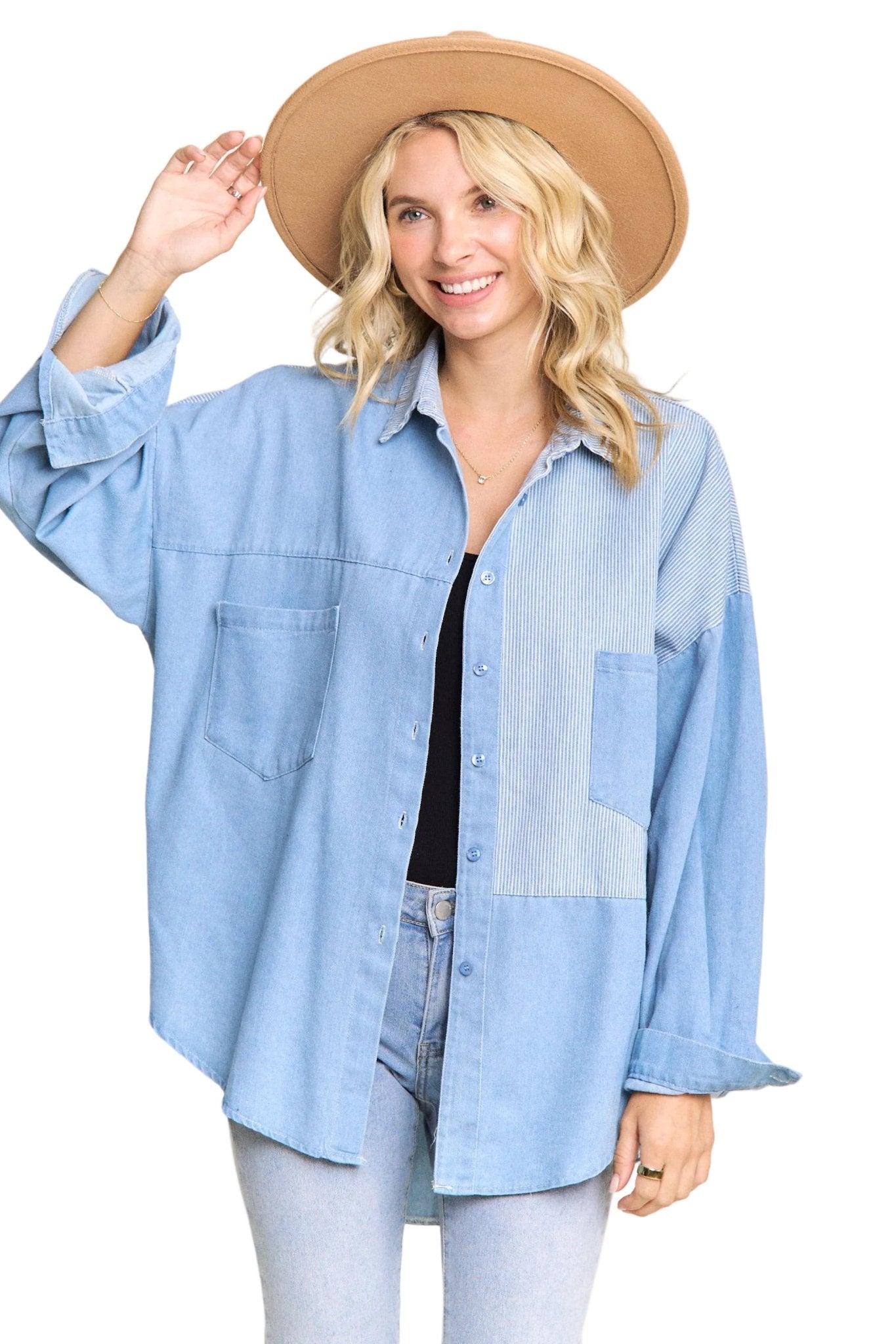 Woman wearing a light blue denim shirt and beige hat on a plain background