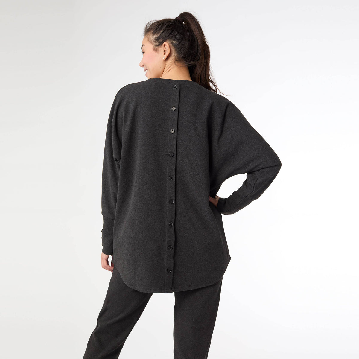 Back view of the black brushed sweater showing the button-back detail
