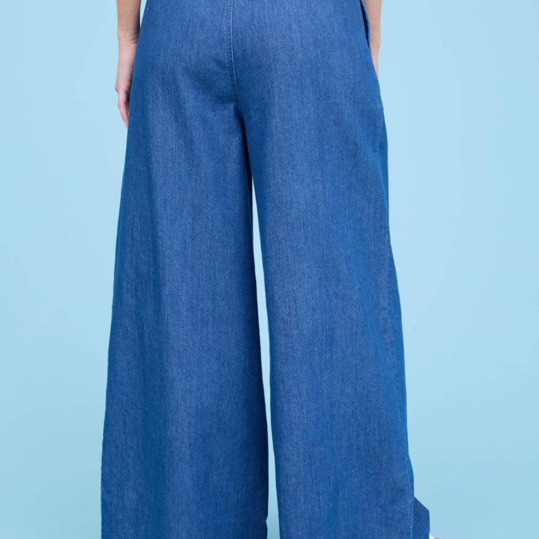 Person wearing blue wide-leg pants on a light blue background
