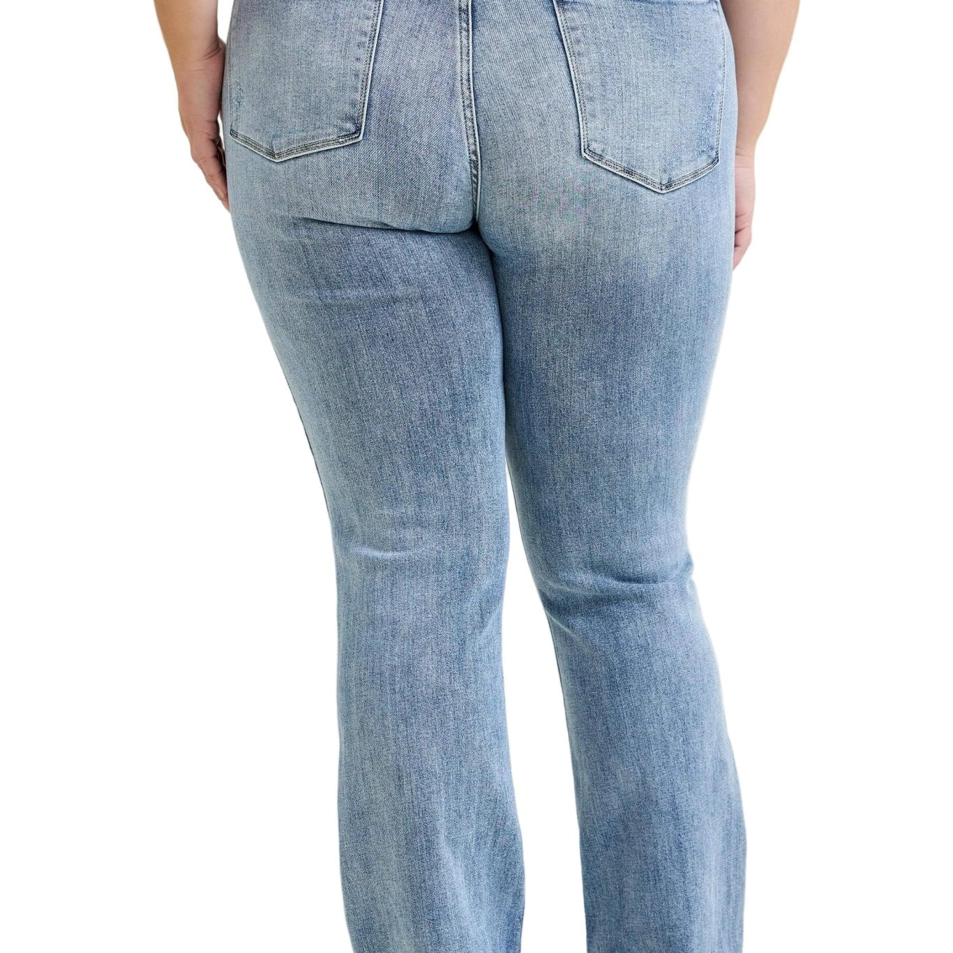 Person wearing light blue jeans on a plain background