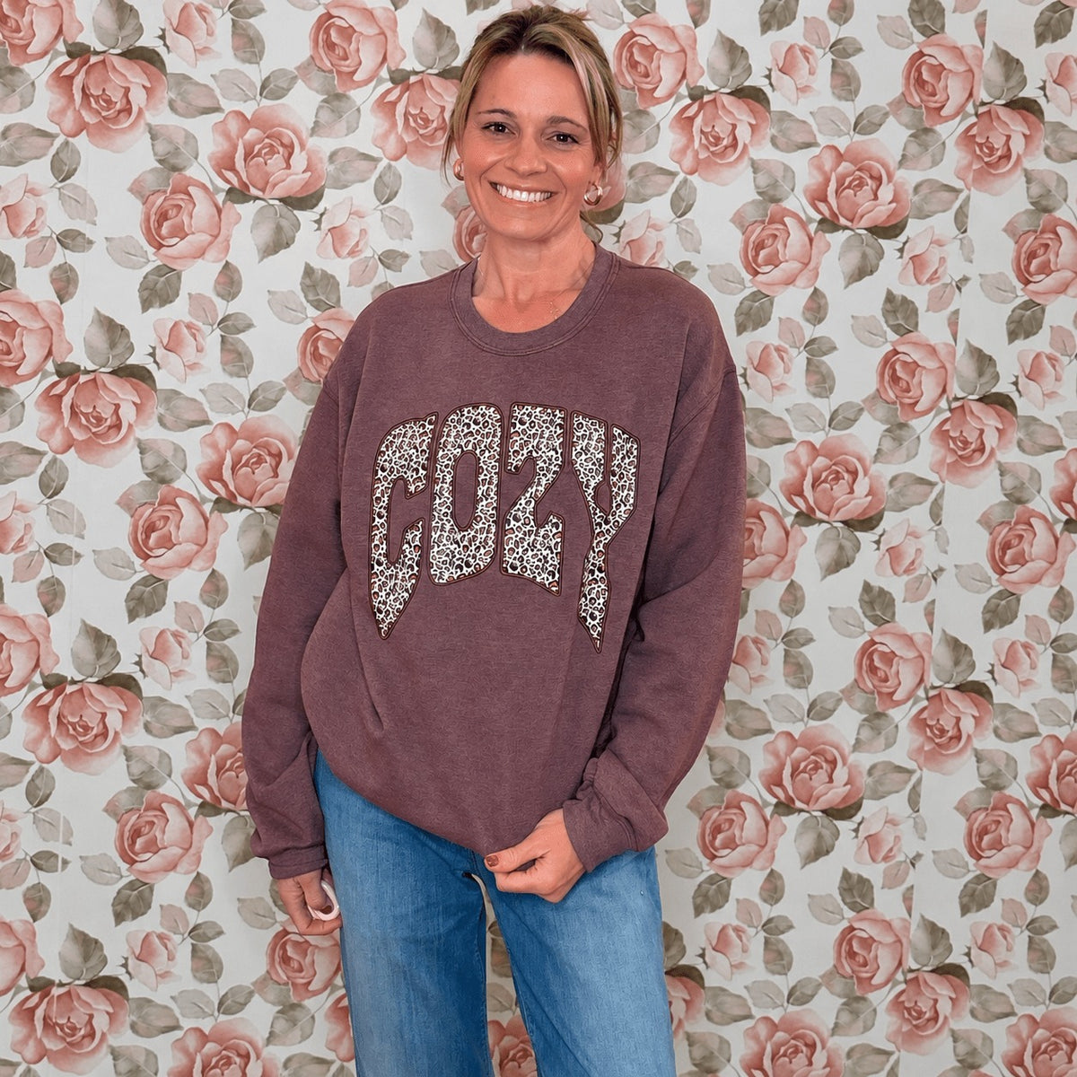 Front view of the heather maroon Leopard Cozy fall sweatshirt styled with jeans