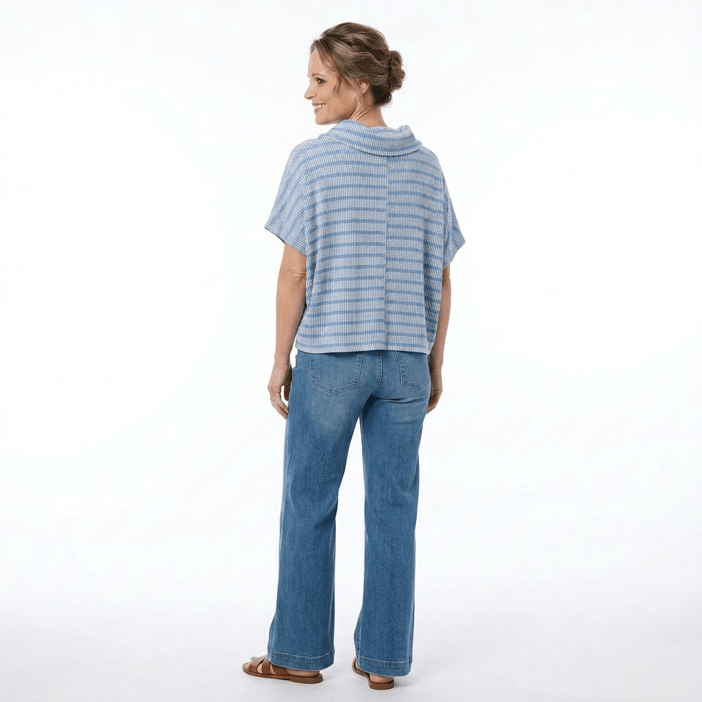 woman in blue shirt and jeans showing the back on a white background