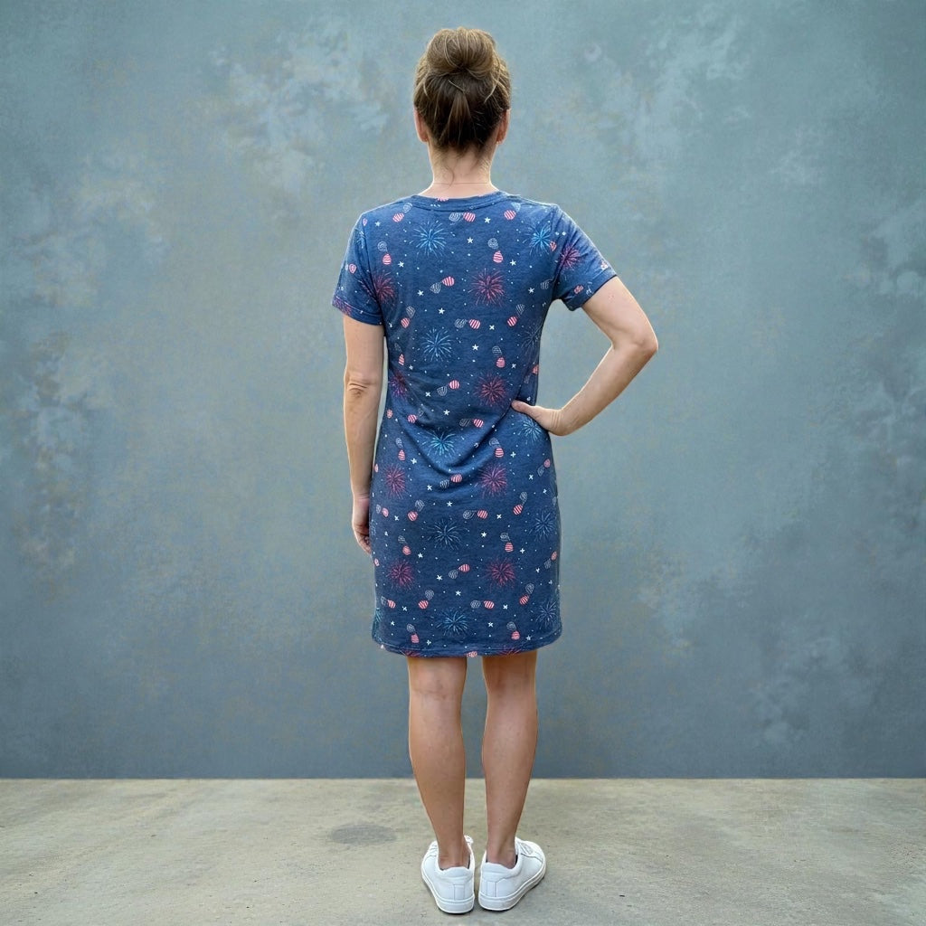 Person wearing a blue firework dress with a pattern against a gray wall