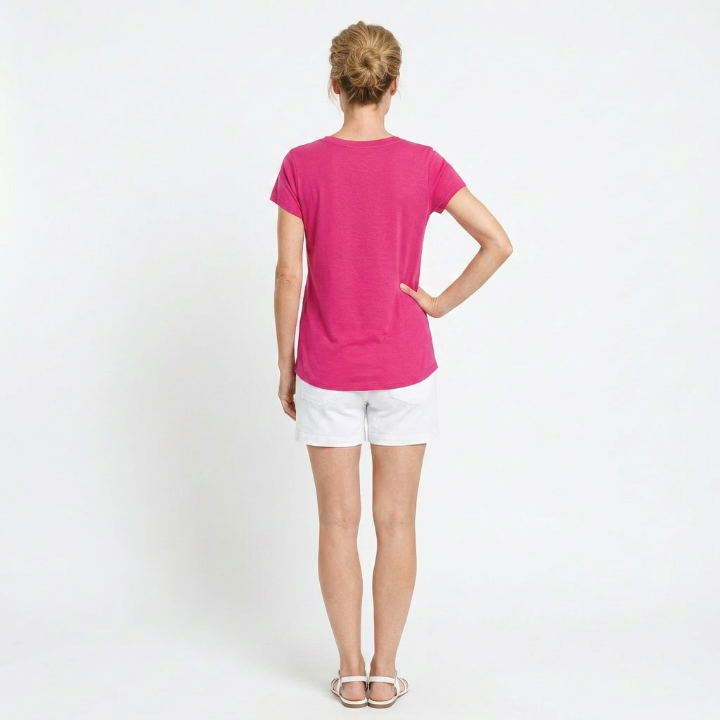 Person wearing a bright pink t-shirt and white shorts on a plain background