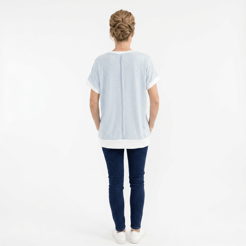 Person wearing a light blue t-shirt and dark blue jeans on a white background