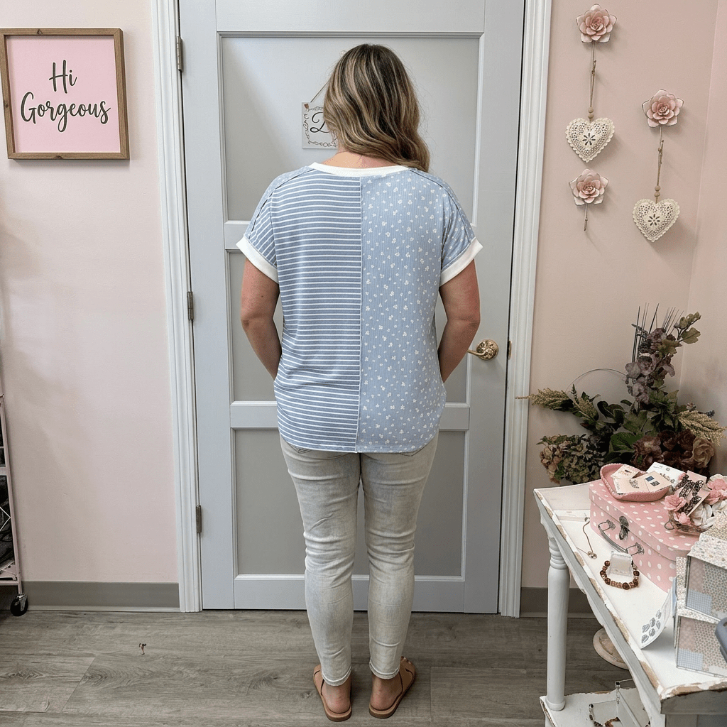 Woman standing in a room with decorative elements and a mirror.