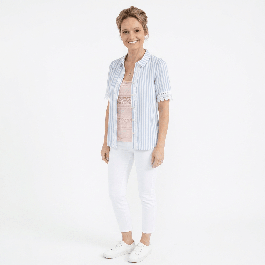 Woman wearing a light blue striped shirt and white pants on a white background