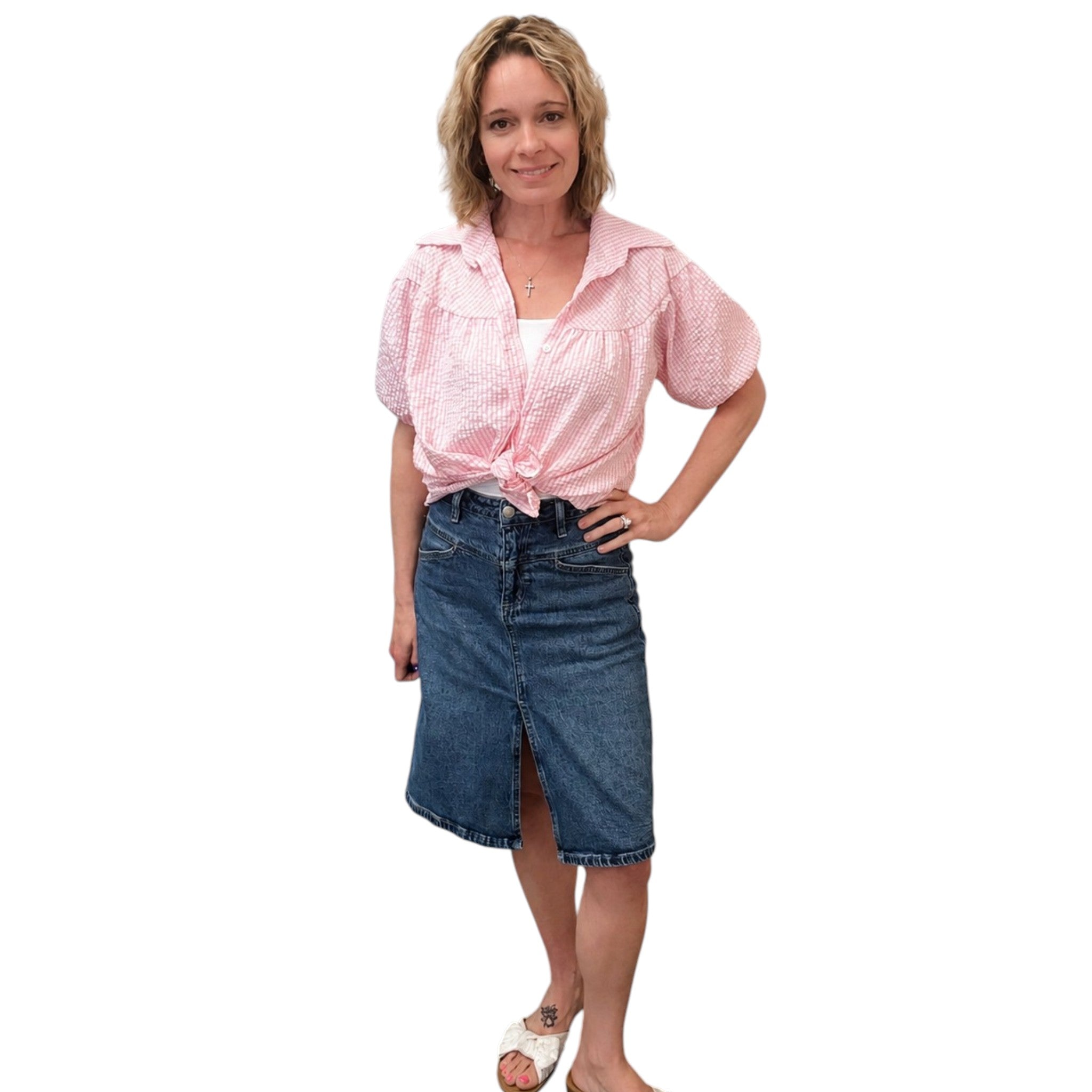 Woman wearing a pink blouse and blue denim skirt on a white background