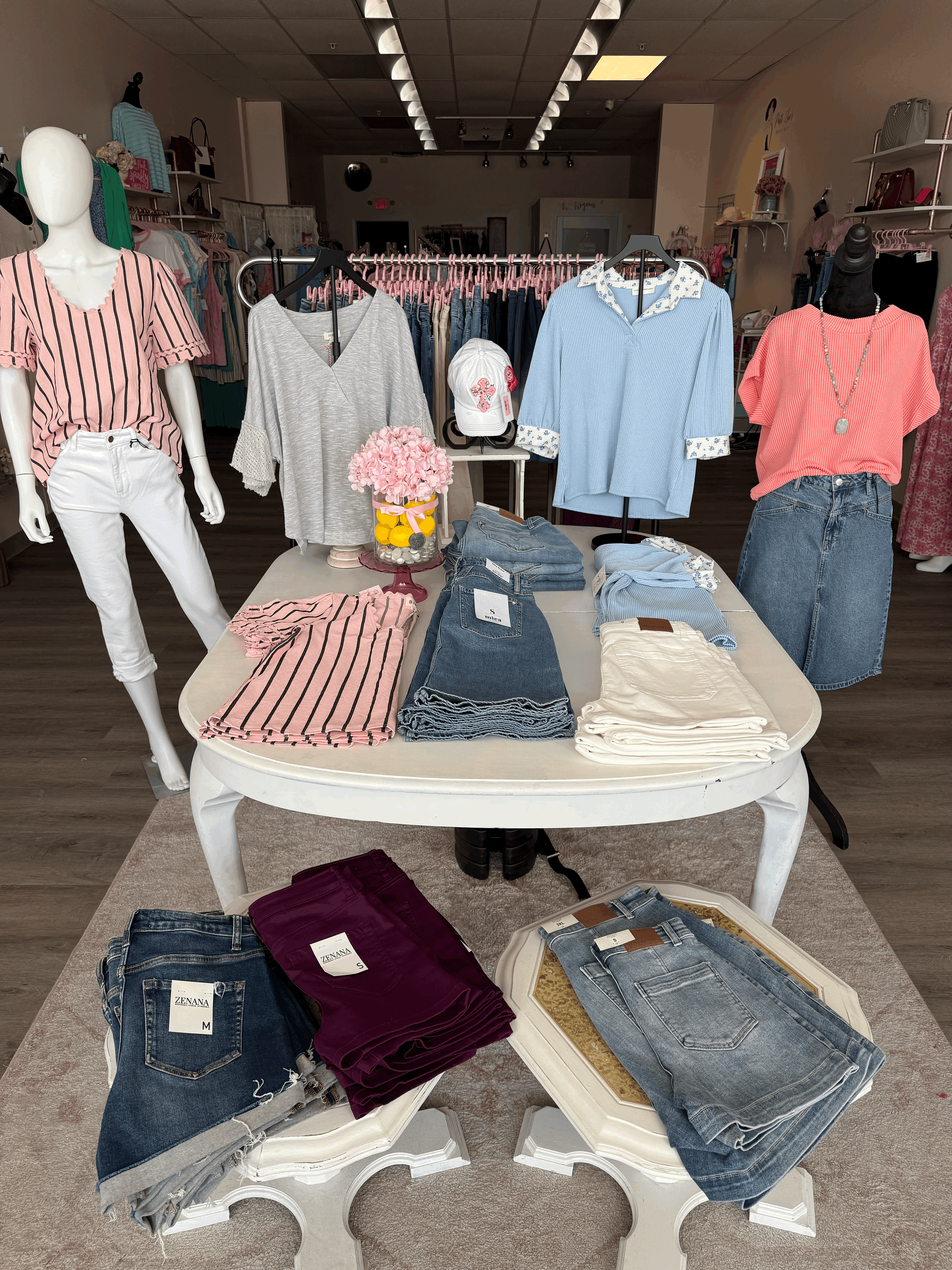 picture of white table with different colored tops and shorts folded on display.