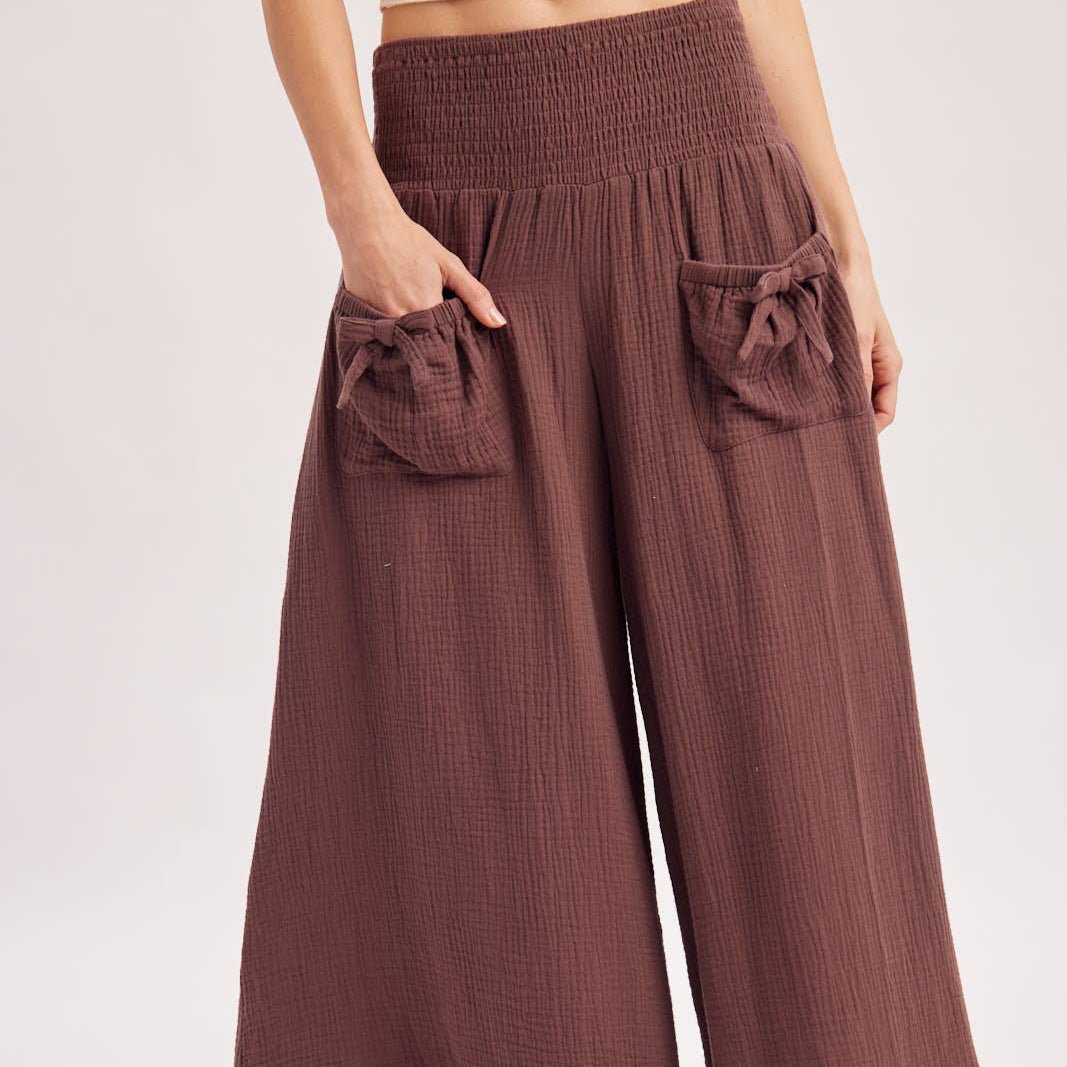 Brown wide-leg pants with ruffled edges on a white background