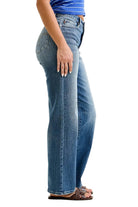 Person wearing blue jeans on a plain background