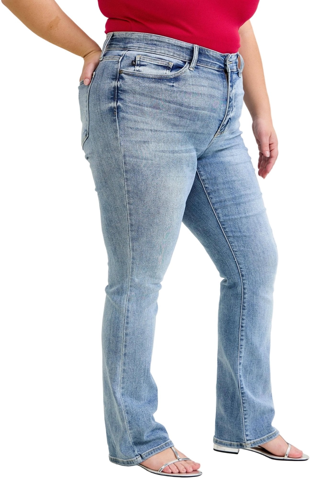 Person wearing blue jeans and a red top on a plain background