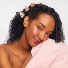 Smiling woman wearing a Kitsch mini cloud claw clip in her hair