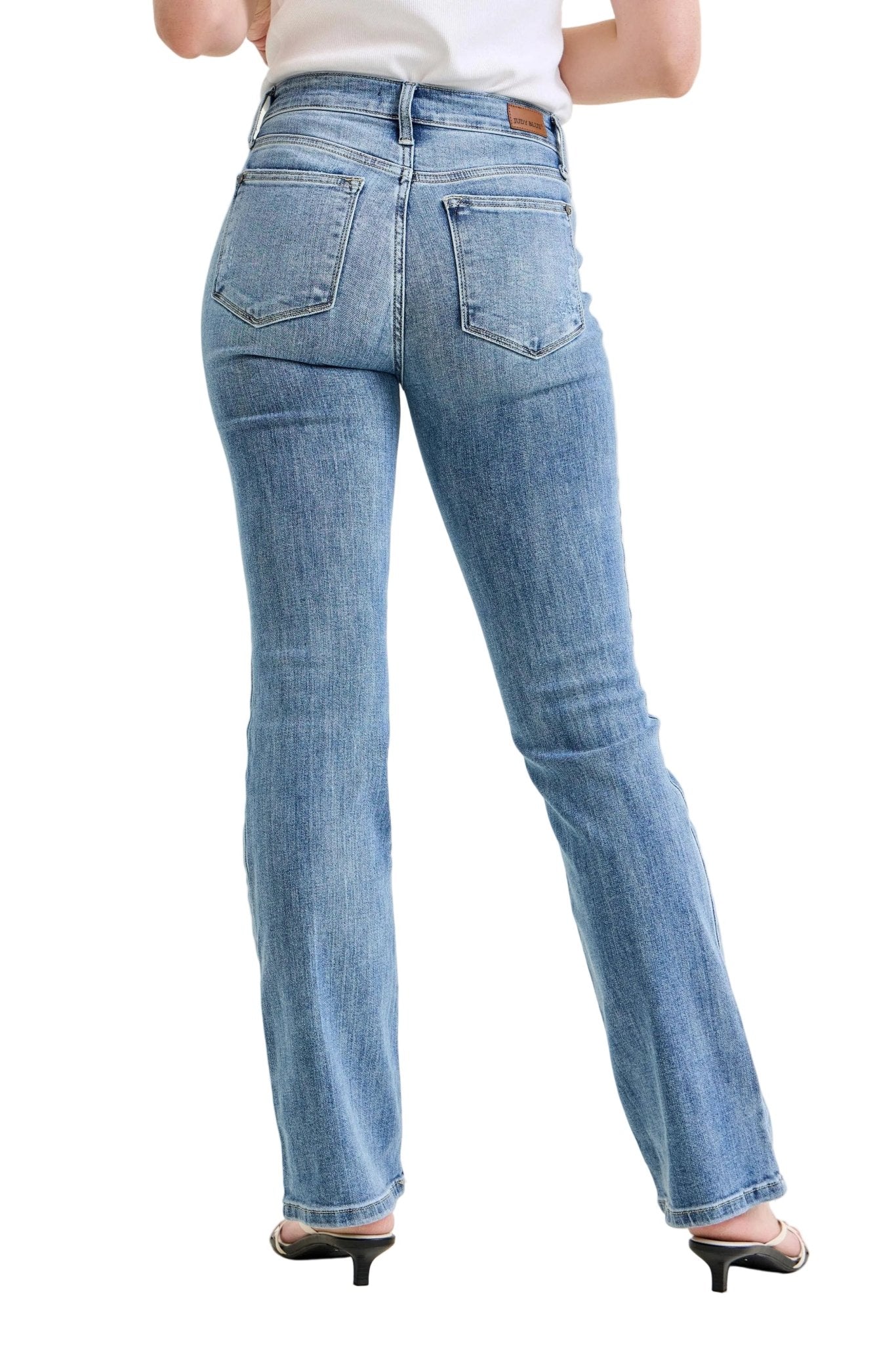 Person wearing blue jeans on a plain background