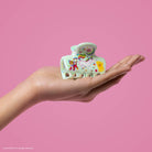 Lisa Frank x Kitsch Markie Cloud Clip held in an open palm on a pink background