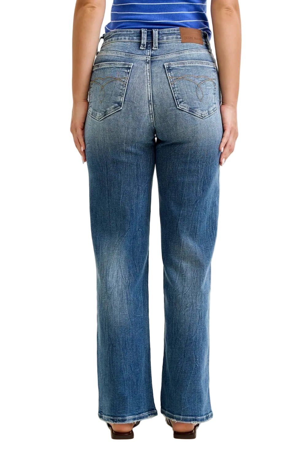 Person wearing blue jeans on a plain background