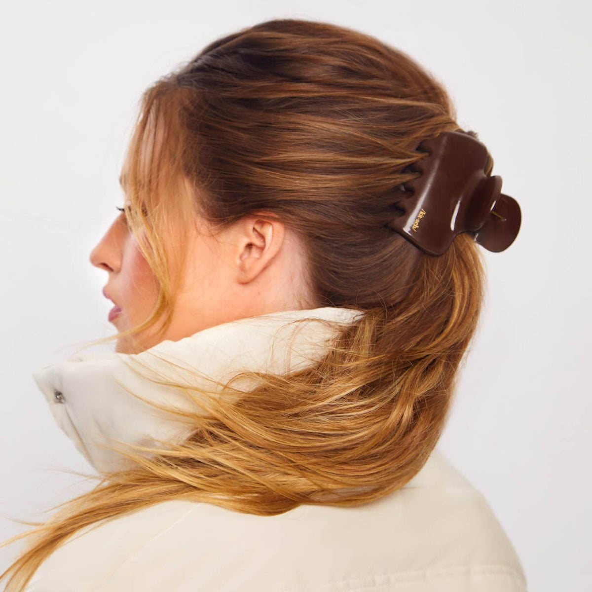 Woman with hair twisted up in a chocolate brown puffy cloud claw clip