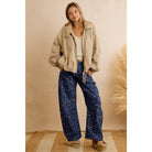 Woman wearing navy floral print wide leg pants with a cream sherpa jacket for a cozy fall outfit