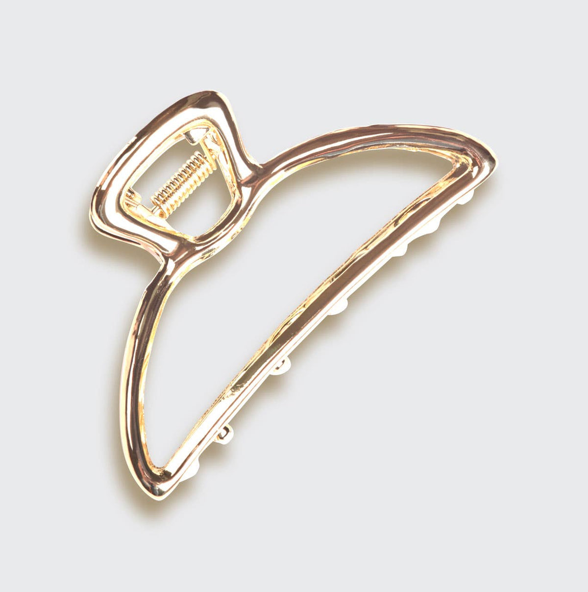 Gold minimalist open shape claw clip from the side on white