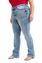 Person wearing light blue jeans on a plain background