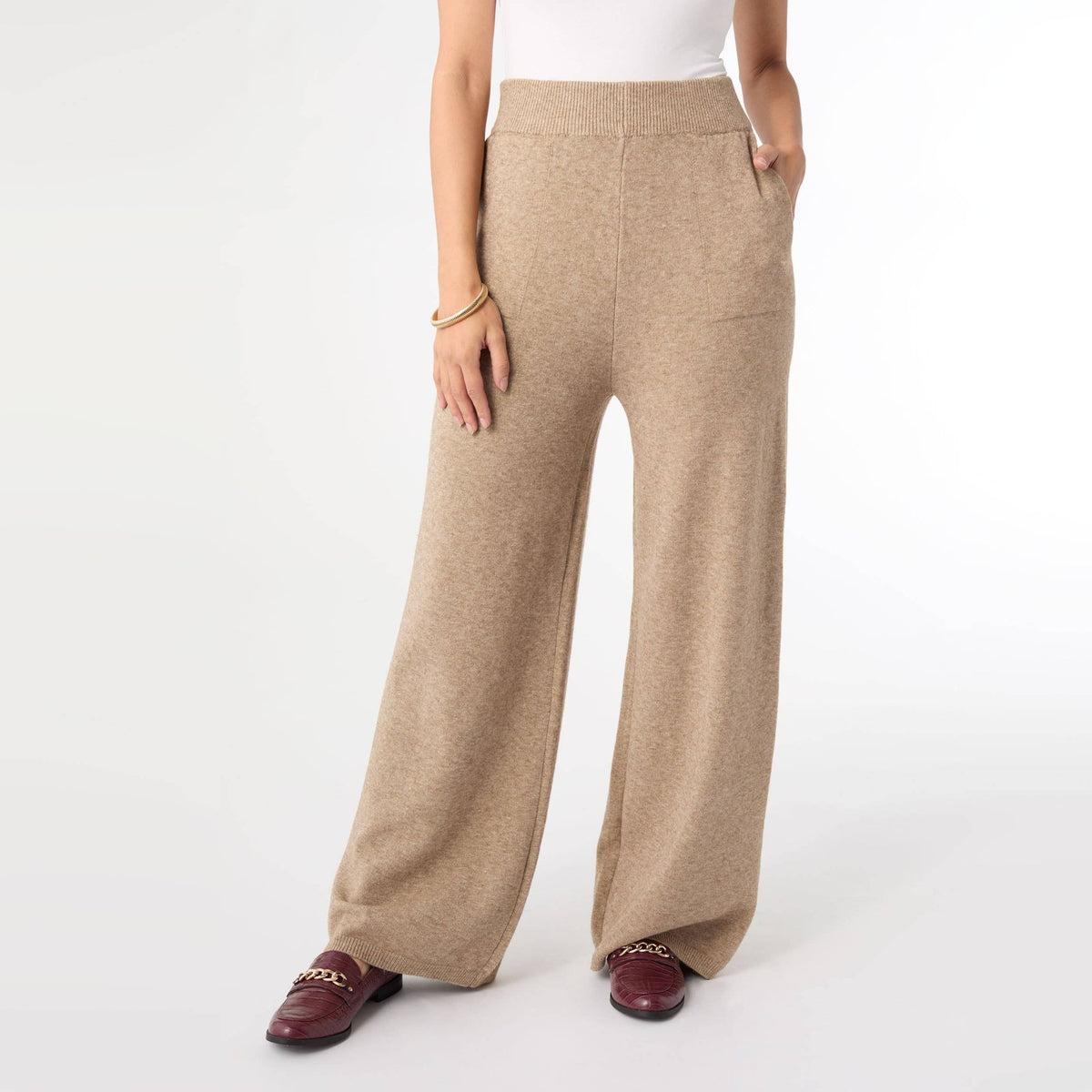 Woman wearing beige heather knit wide leg lounge pants with a white tee and loafers