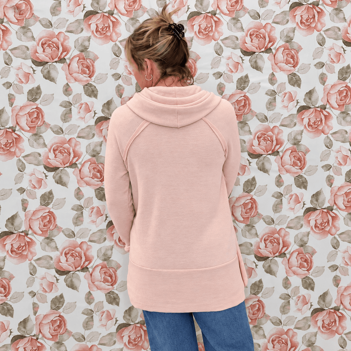 Back view of the smoke pink cowl neck top showing the raglan sleeves and banded tunic hem