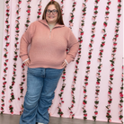 Plus size model in a dusty pink pointelle knit half zip sweater styled with wide leg jeans