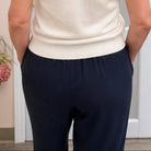 backside of blue pants with a white sweater
