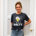 woman wearing a tshirt with the word salty and picture of a girl with an umbrella in the rain