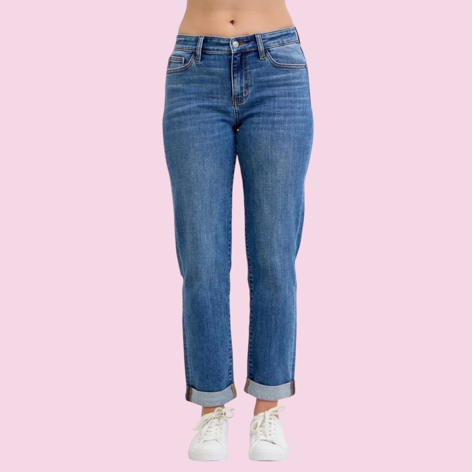 Blue jeans worn by a person on a pink background
