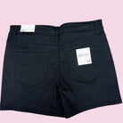 Black shorts with a brand label on a pink background
