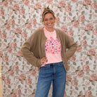 Pink floral pumpkin graphic tee styled with a tan cardigan and medium wash jeans for a fall outfit