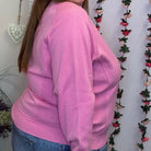 Side view of the plus size pink crewneck sweatshirt showing the relaxed fit and long sleeves