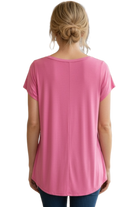 Pink t-shirt worn by a person on a white background