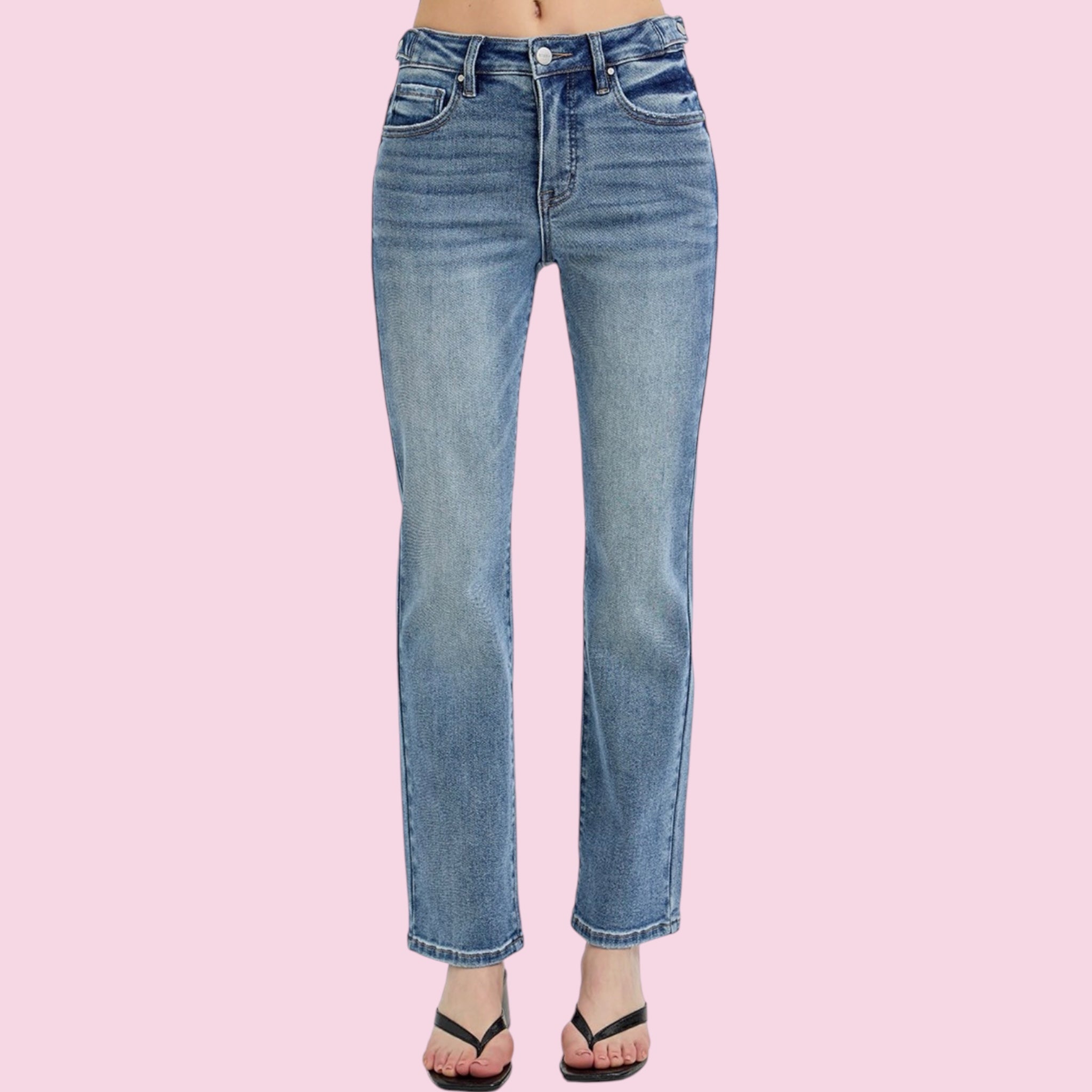 Blue jeans on a person against a pink background