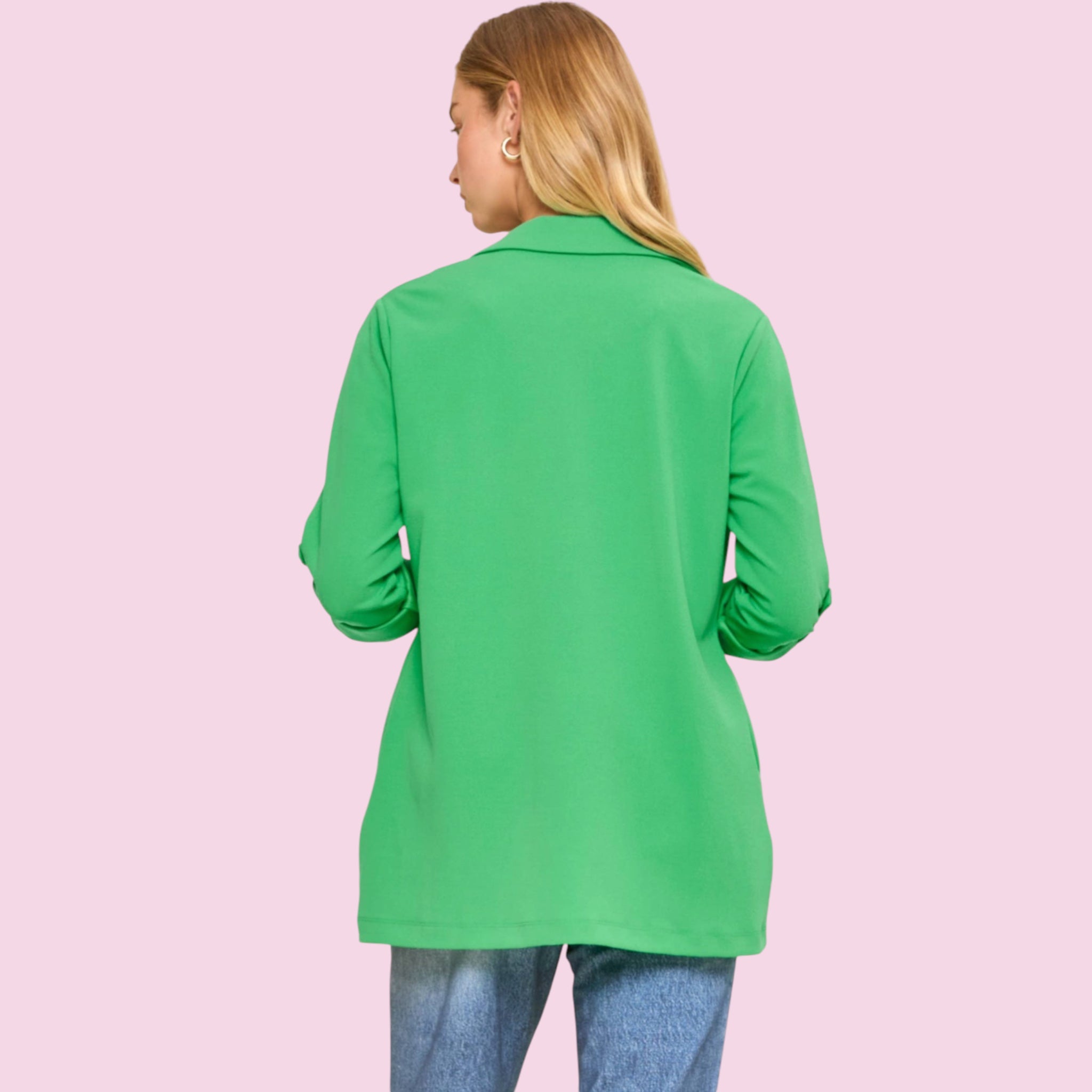 Person wearing a green long-sleeve shirt on a pink background