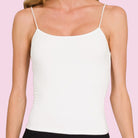 woman wearing white cami on pink background