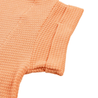 Close-up of peach-colored textured fabric on a white background