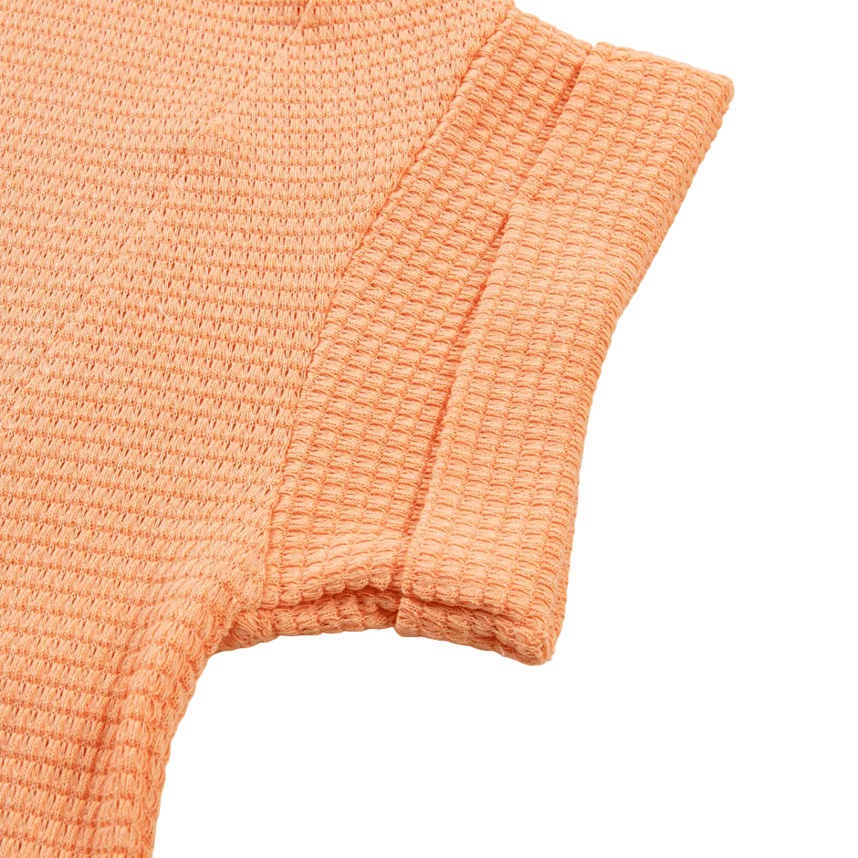 Close-up of peach-colored textured fabric on a white background
