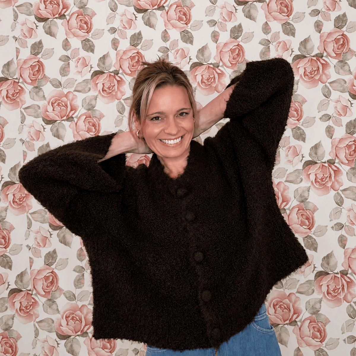 Woman wearing a chocolate brown fuzzy knit button-front cardigan with an oversized, relaxed fit and light wash jeans