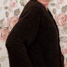 Close-up side view of chocolate brown cardigan showing the soft, nubby boucle knit texture