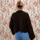 Back view of chocolate brown fuzzy knit cardigan showing the cropped, boxy fit and wide sleeves